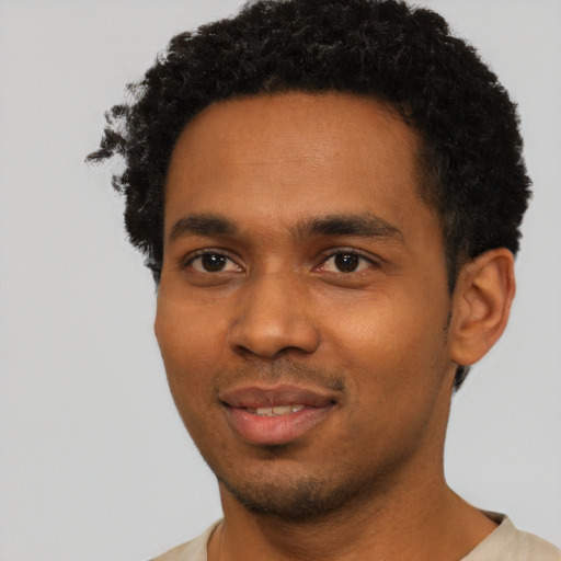 Joyful black young-adult male with short  black hair and brown eyes
