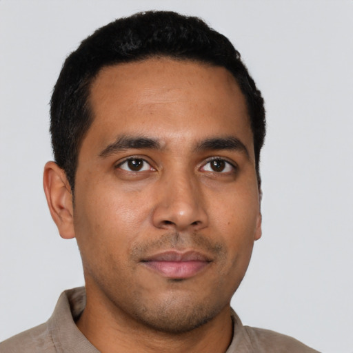Joyful latino young-adult male with short  black hair and brown eyes