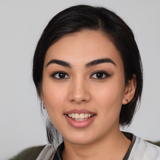 Joyful latino young-adult female with medium  black hair and brown eyes