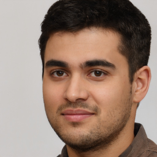 Joyful white young-adult male with short  black hair and brown eyes