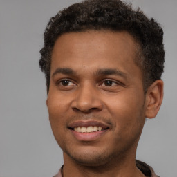 Joyful black young-adult male with short  brown hair and brown eyes