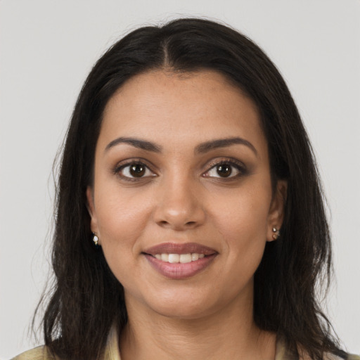 Joyful black young-adult female with long  brown hair and brown eyes