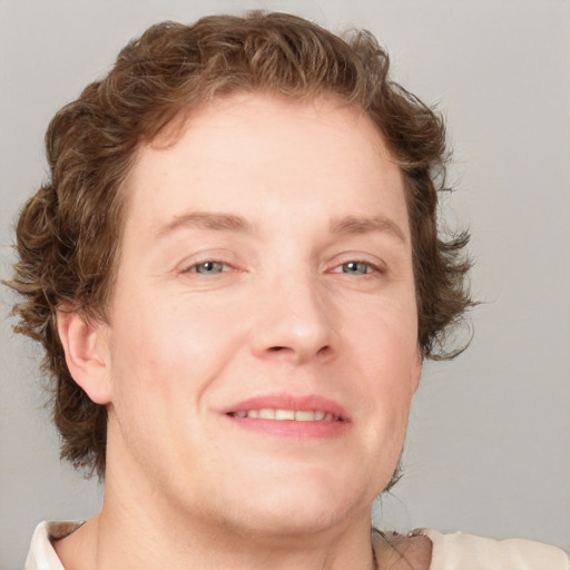 Joyful white young-adult male with short  brown hair and blue eyes