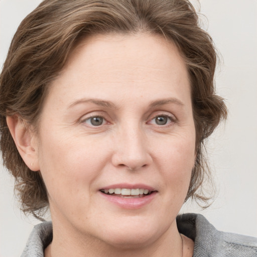 Joyful white adult female with medium  brown hair and grey eyes