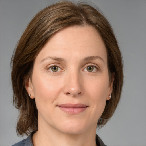 Joyful white young-adult female with medium  brown hair and grey eyes