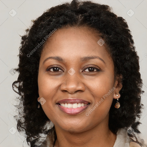 Joyful black adult female with long  brown hair and brown eyes