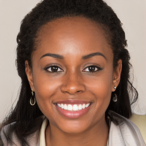 Joyful black young-adult female with long  brown hair and brown eyes