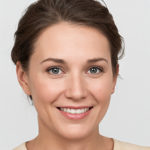 Joyful white young-adult female with medium  brown hair and grey eyes