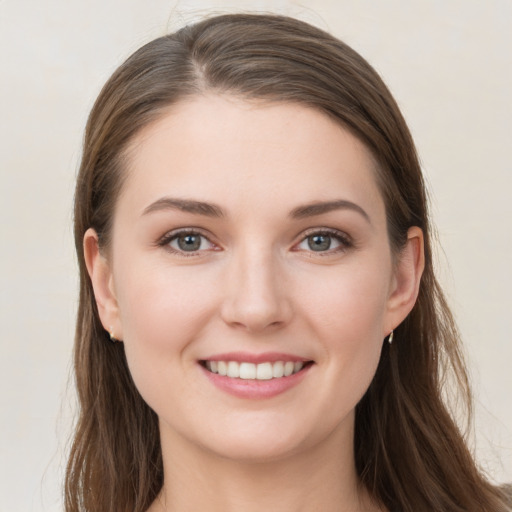 Joyful white young-adult female with long  brown hair and grey eyes