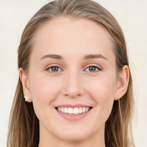 Joyful white young-adult female with long  brown hair and blue eyes