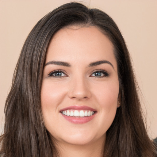 Joyful white young-adult female with long  brown hair and brown eyes