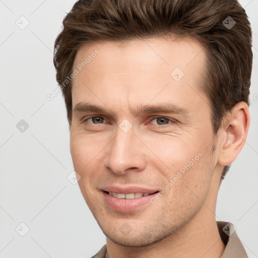 Joyful white young-adult male with short  brown hair and grey eyes