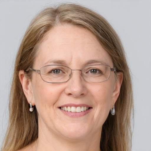 Joyful white middle-aged female with long  brown hair and blue eyes