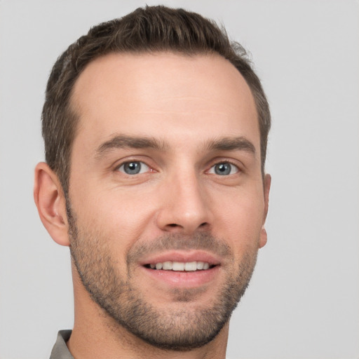 Joyful white young-adult male with short  brown hair and grey eyes