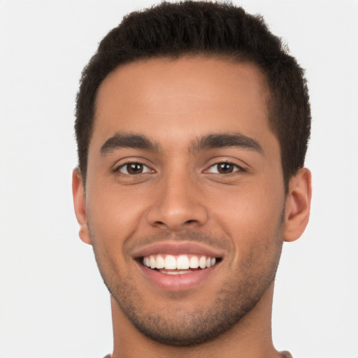 Joyful latino young-adult male with short  brown hair and brown eyes