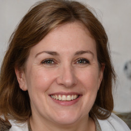 Joyful white adult female with medium  brown hair and brown eyes