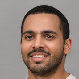 Joyful latino young-adult male with short  black hair and brown eyes