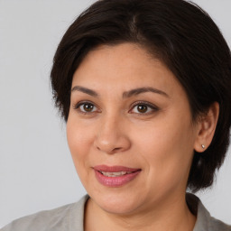 Joyful white adult female with medium  brown hair and brown eyes