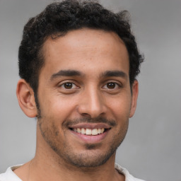 Joyful latino young-adult male with short  brown hair and brown eyes