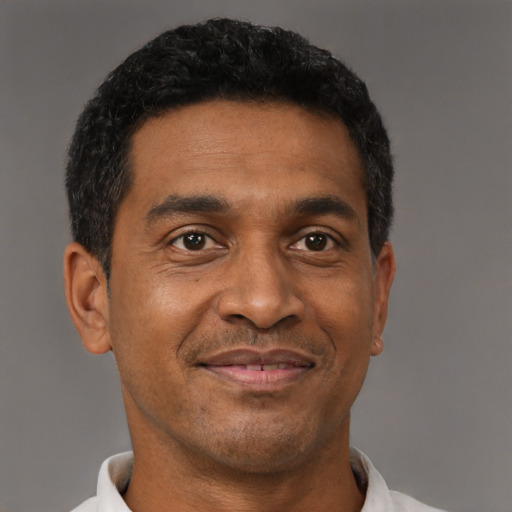Joyful black adult male with short  brown hair and brown eyes