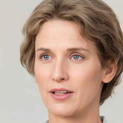 Joyful white adult female with medium  brown hair and grey eyes