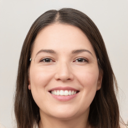 Joyful white young-adult female with long  brown hair and brown eyes