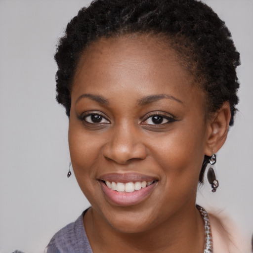 Joyful black young-adult female with long  brown hair and brown eyes