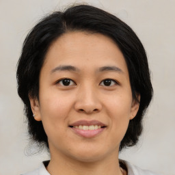 Joyful asian young-adult female with medium  black hair and brown eyes