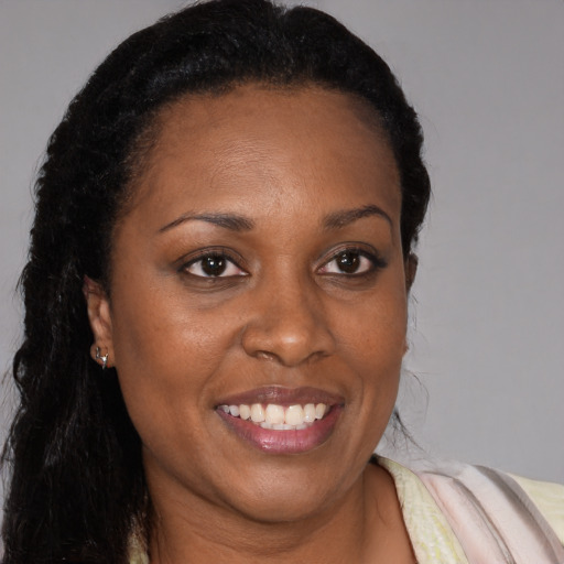 Joyful black young-adult female with long  brown hair and brown eyes