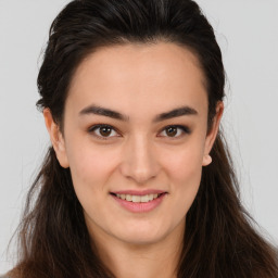 Joyful white young-adult female with long  brown hair and brown eyes