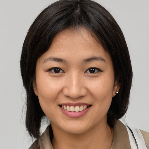 Joyful asian young-adult female with medium  brown hair and brown eyes