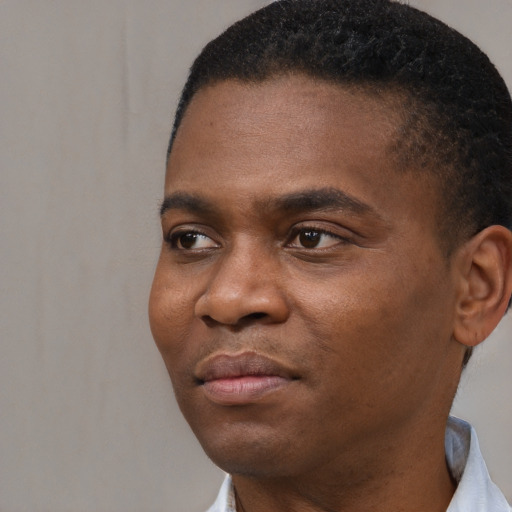 Joyful black young-adult male with short  black hair and brown eyes
