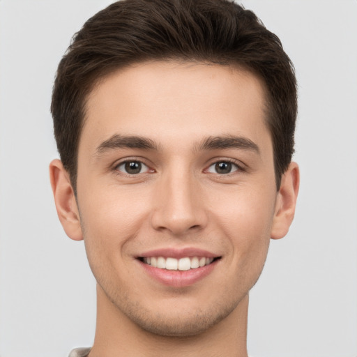 Joyful white young-adult male with short  brown hair and brown eyes