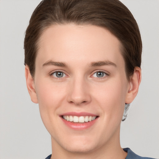 Joyful white young-adult female with short  brown hair and grey eyes