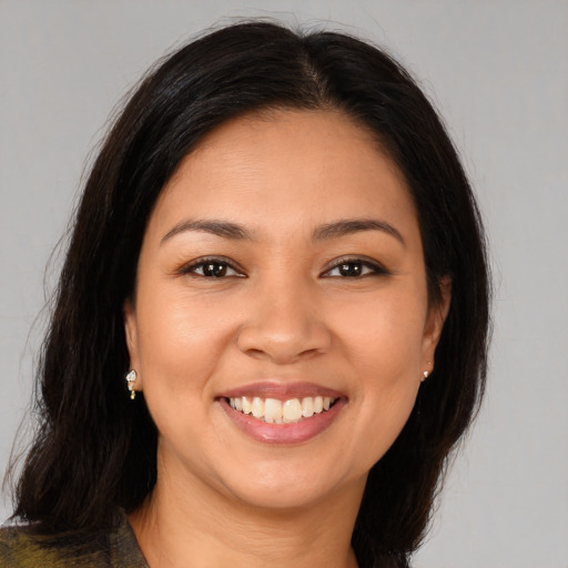 Joyful latino young-adult female with long  brown hair and brown eyes