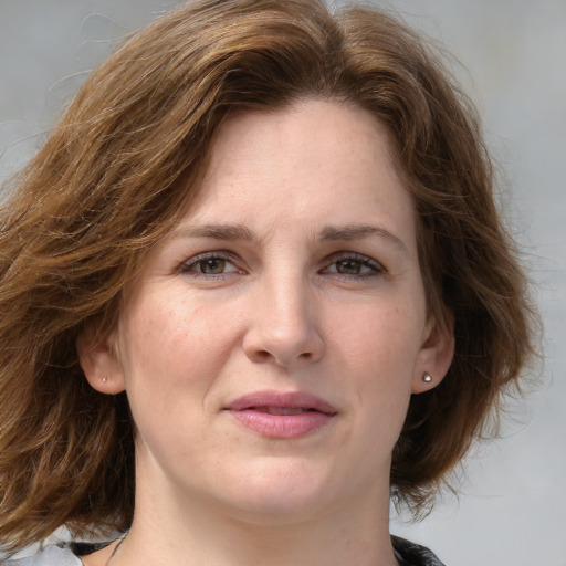 Joyful white young-adult female with medium  brown hair and blue eyes