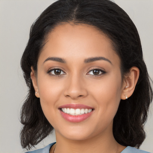 Joyful latino young-adult female with long  brown hair and brown eyes