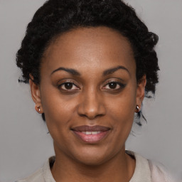 Joyful black young-adult female with short  black hair and brown eyes