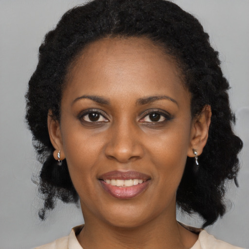 Joyful black young-adult female with medium  black hair and brown eyes