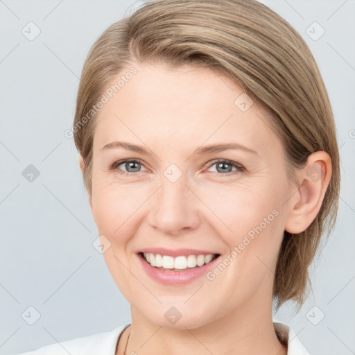 Joyful white young-adult female with medium  brown hair and grey eyes