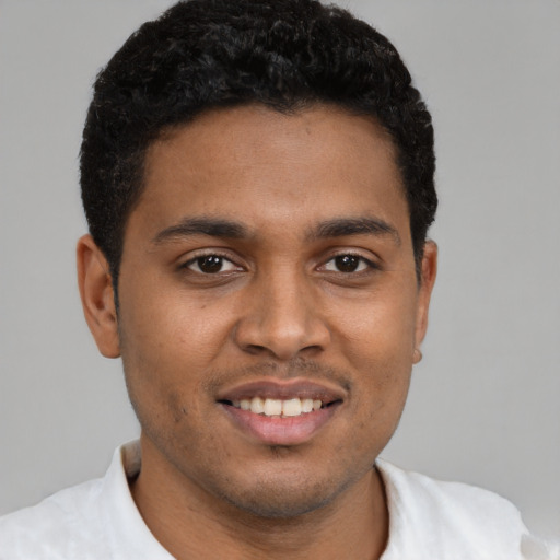 Joyful black young-adult male with short  brown hair and brown eyes