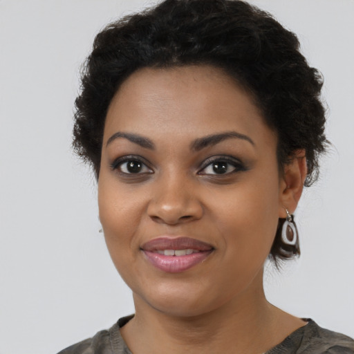 Joyful black young-adult female with medium  brown hair and brown eyes