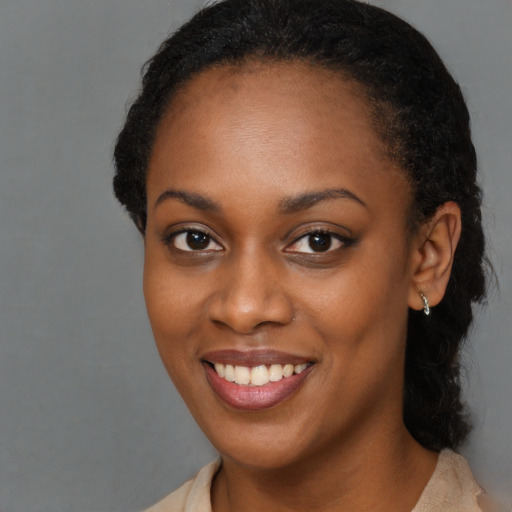 Joyful black young-adult female with long  brown hair and brown eyes