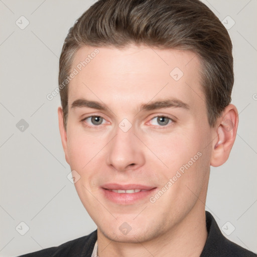 Joyful white young-adult male with short  brown hair and grey eyes