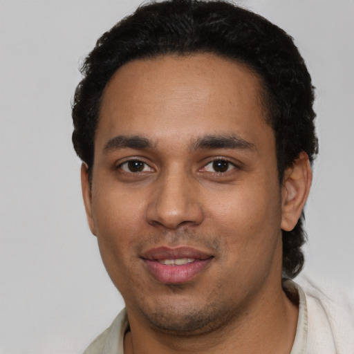 Joyful latino young-adult male with short  black hair and brown eyes