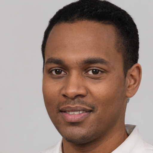 Joyful black young-adult male with short  black hair and brown eyes