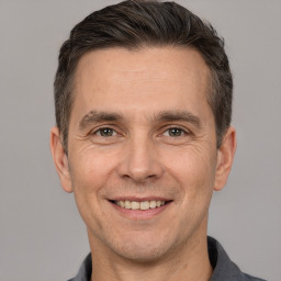 Joyful white adult male with short  brown hair and brown eyes