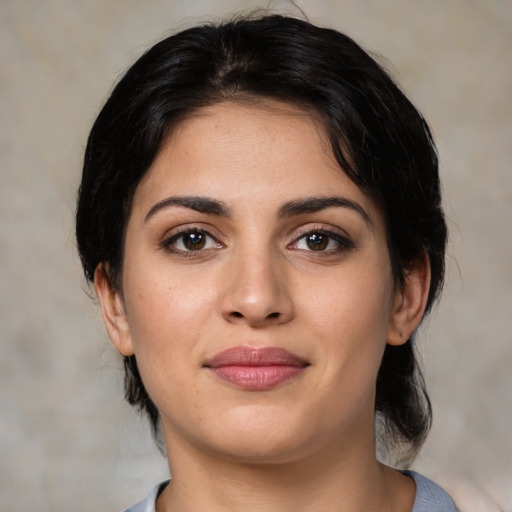 Joyful white young-adult female with medium  black hair and brown eyes