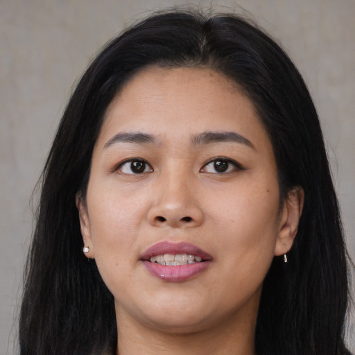 Joyful asian young-adult female with long  brown hair and brown eyes