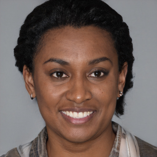 Joyful black young-adult female with short  black hair and brown eyes